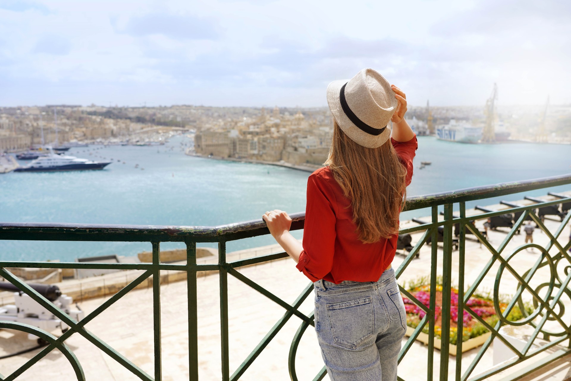 Valletta’daki Upper Barrakka Bahçeleri’nden Üç Şehir manzarasının tadını çıkaran genç bir kadın